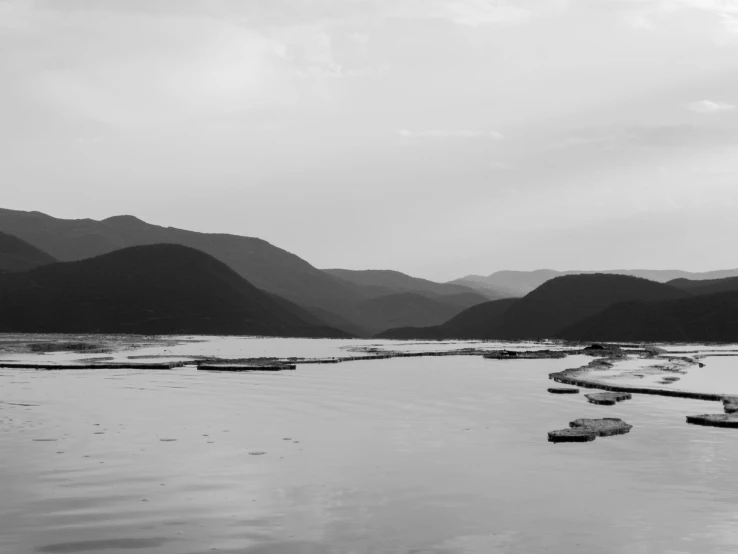 black and white pograph of mountains surrounding a large lake