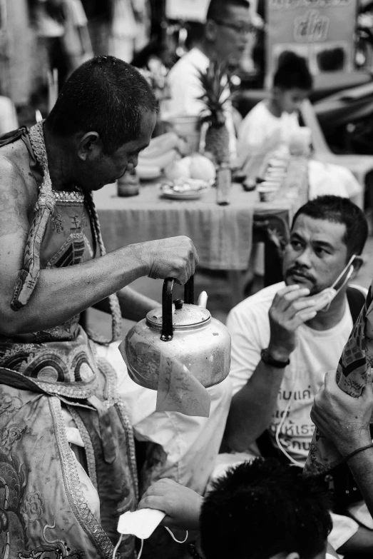 a man in a costume pours soing from a can into his mouth