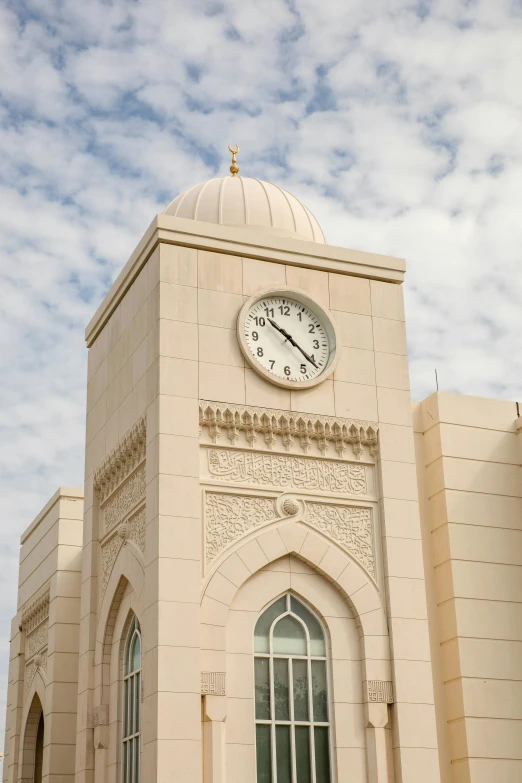 a clock tower sitting above a doorway under a blue cloudy sky