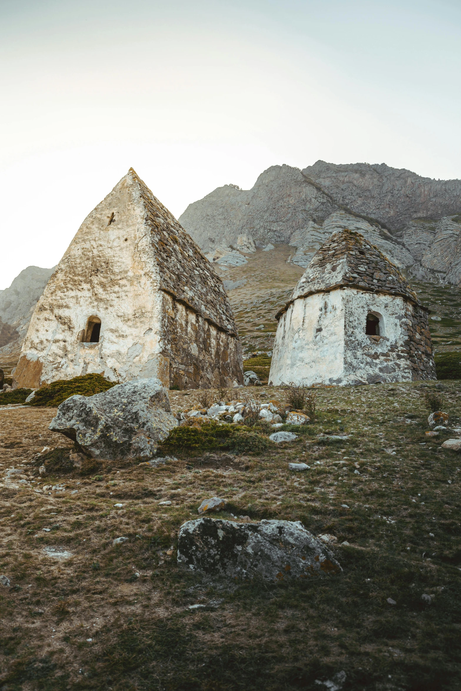 several stone buildings are on the side of a mountain