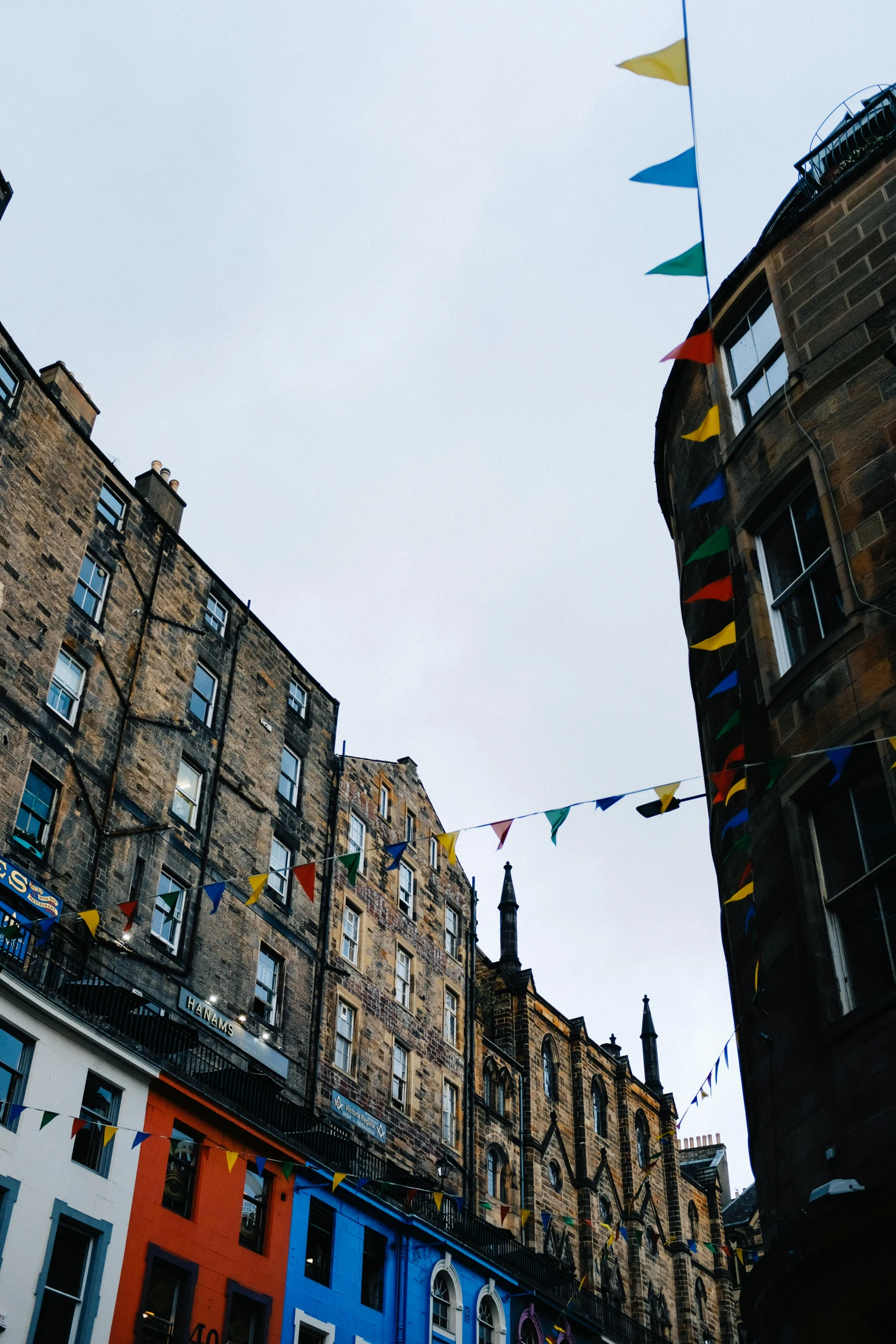 a multicolored stream of kites above several buildings