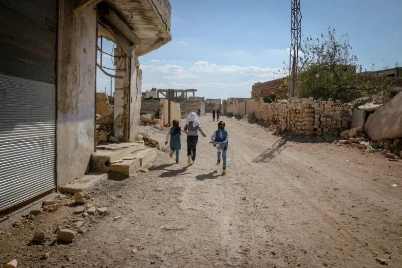 a group of people walking down a dirt road