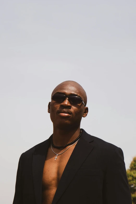 a man with a sun glasses and a necklace on