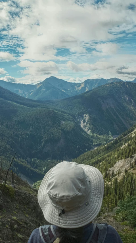 the person has a hat and is looking down the hill