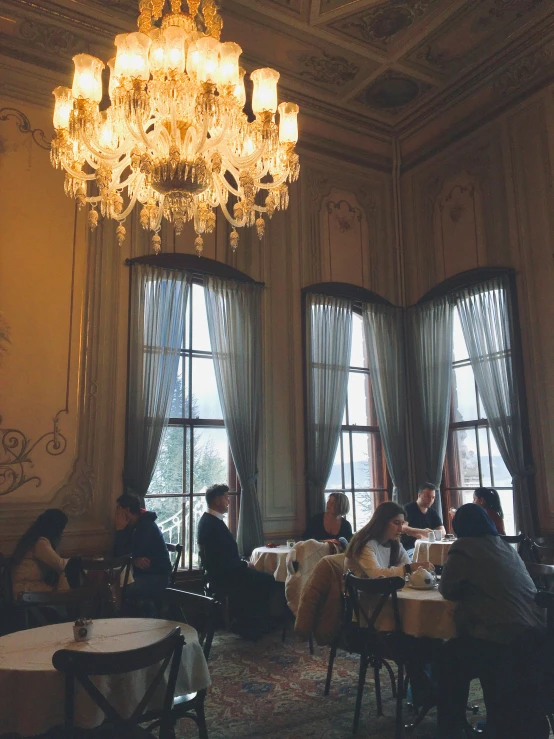 a large chandelier in the middle of two dining tables