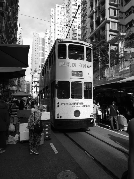 a double decker bus riding down a street in front of tall buildings