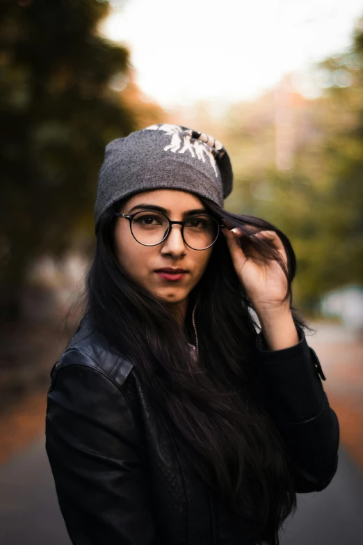 a person with long hair wearing glasses and a beanie