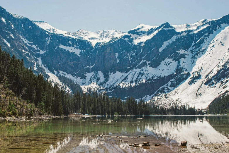 mountain range with a pond on top near a lake