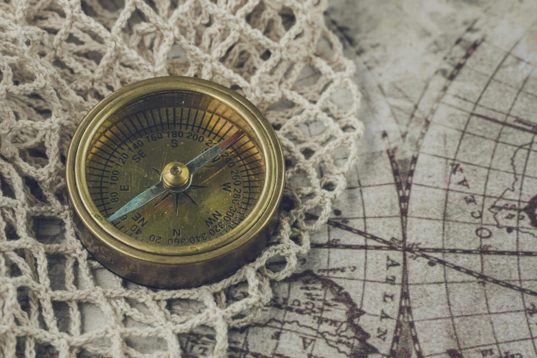 an antique compass lies on the bed fabric