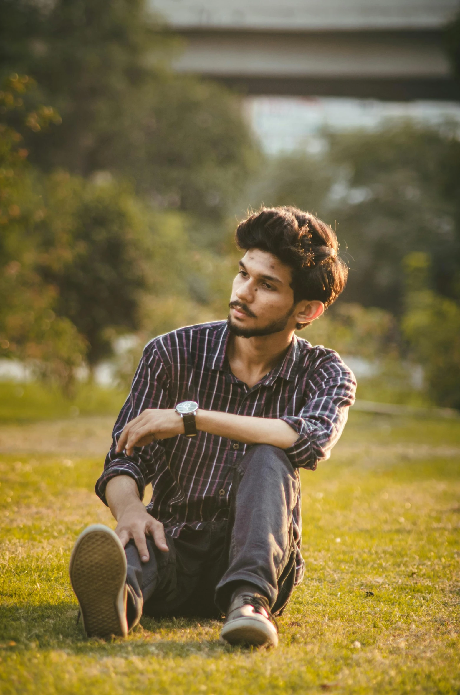 a bearded man poses with his foot on the ground