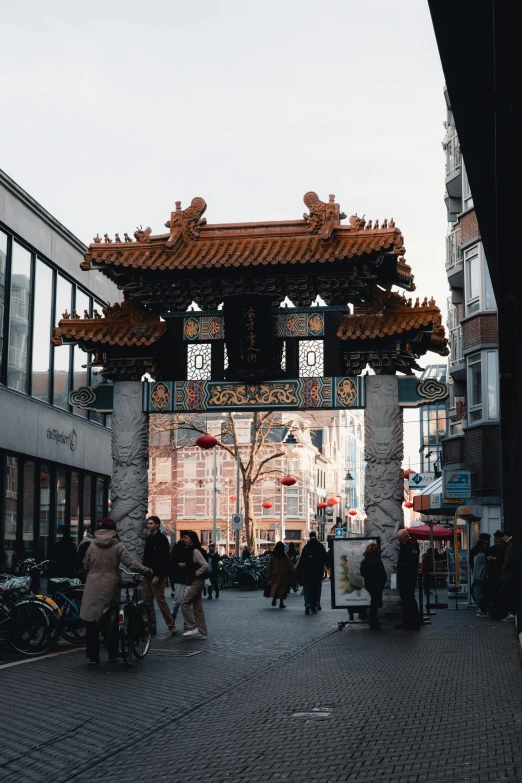 people walking past a decorated archway in a city