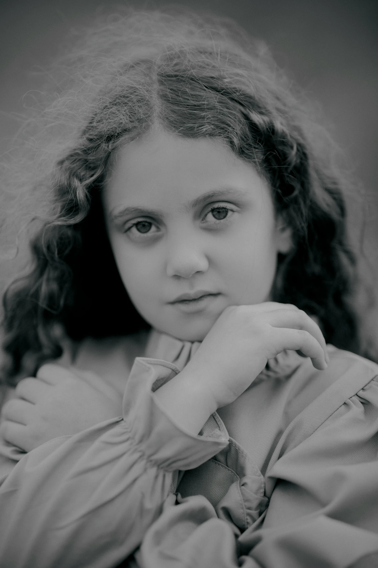 a little girl with curly hair is sitting