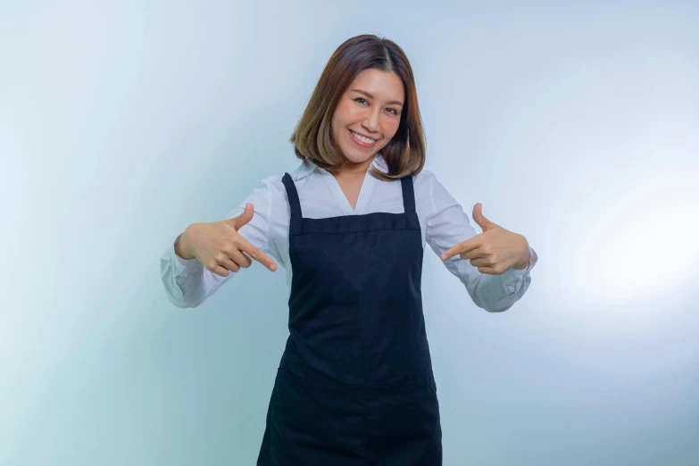 a woman in a blue dress smiles while giving a thumbs up