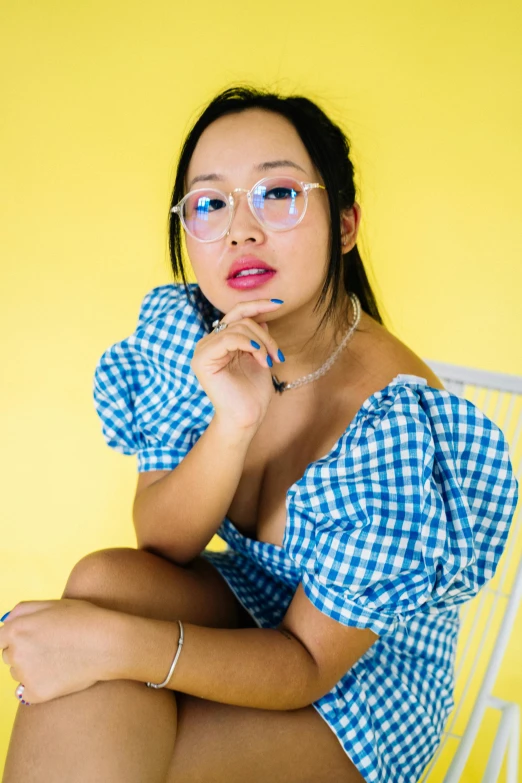 a woman in a gingham top posing for the camera