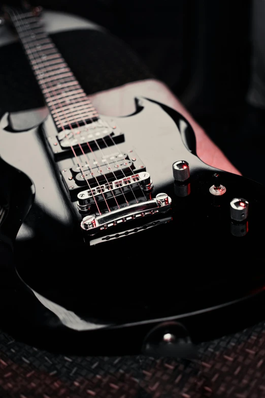 an electric guitar laying on a couch next to an armrest