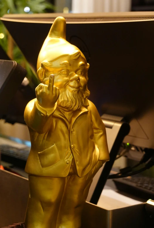 a small gold sculpture standing next to a keyboard