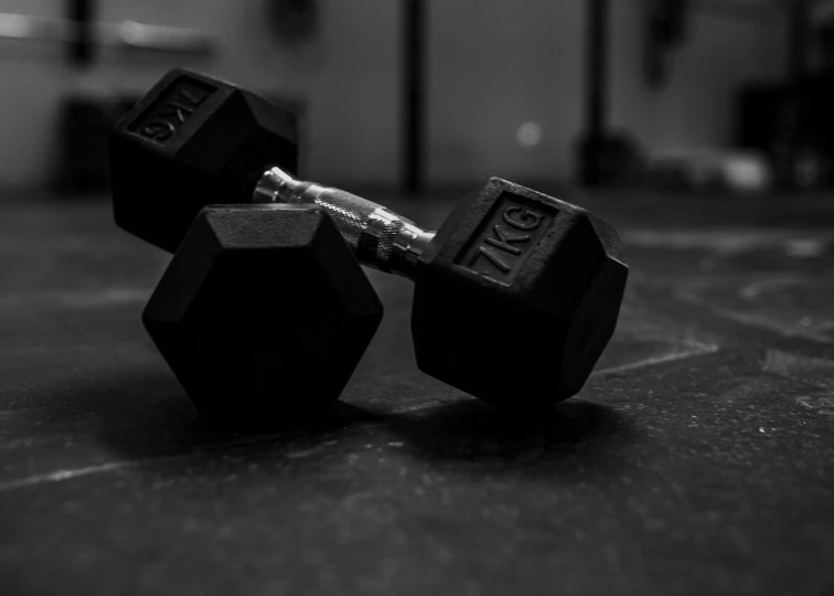 two dumbbells sitting next to each other on the ground