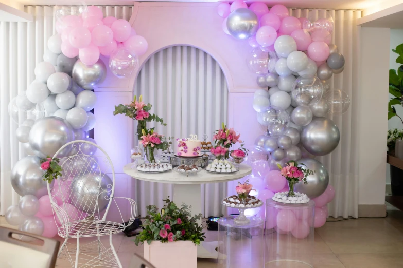 a party room with balloons, flowers and desserts