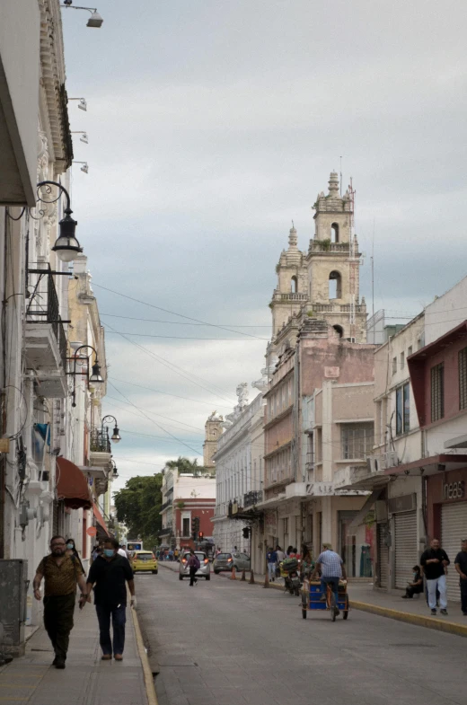 some people walk down a road with some buildings