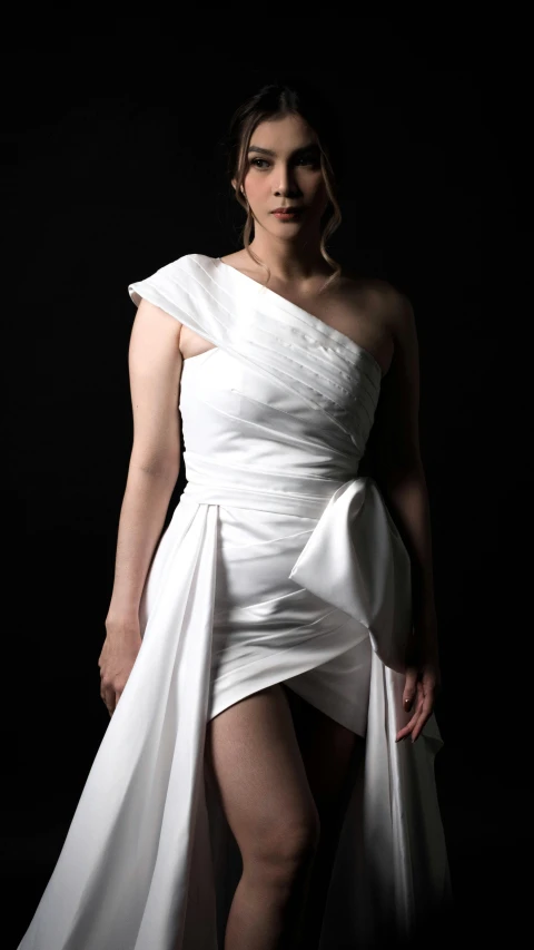 a woman in white dress with dark background