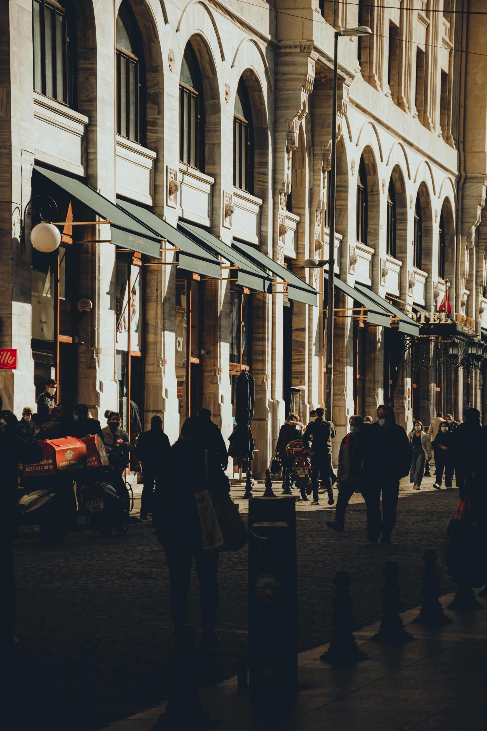 group of people walking past a building down a street