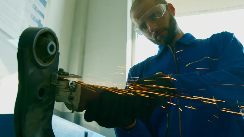 the man in blue is using a metal arc