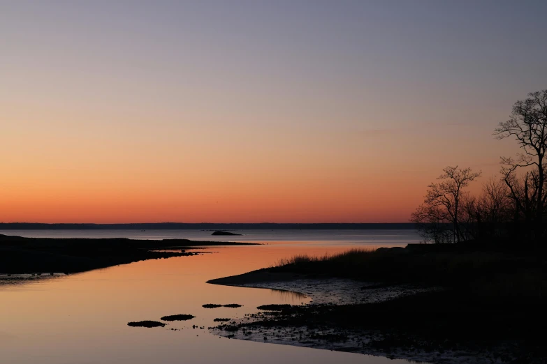 sunset reflected in calm water on a beach