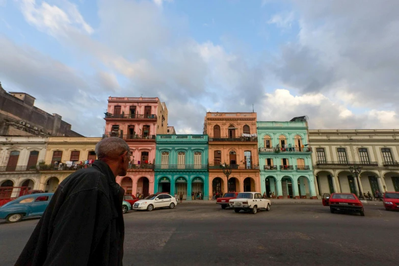 a man in an old street with parked cars