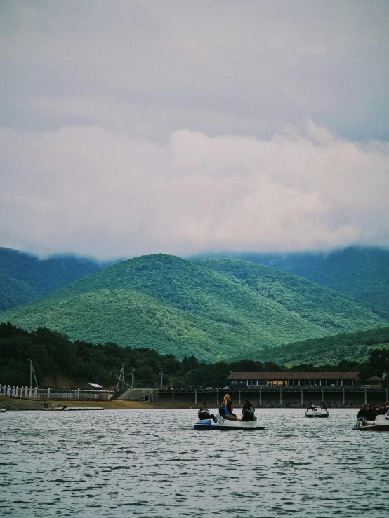 two people rowing in small boats in a large body of water