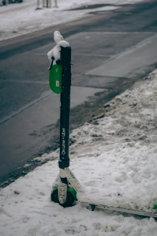 a snow covered parking meter on a street corner