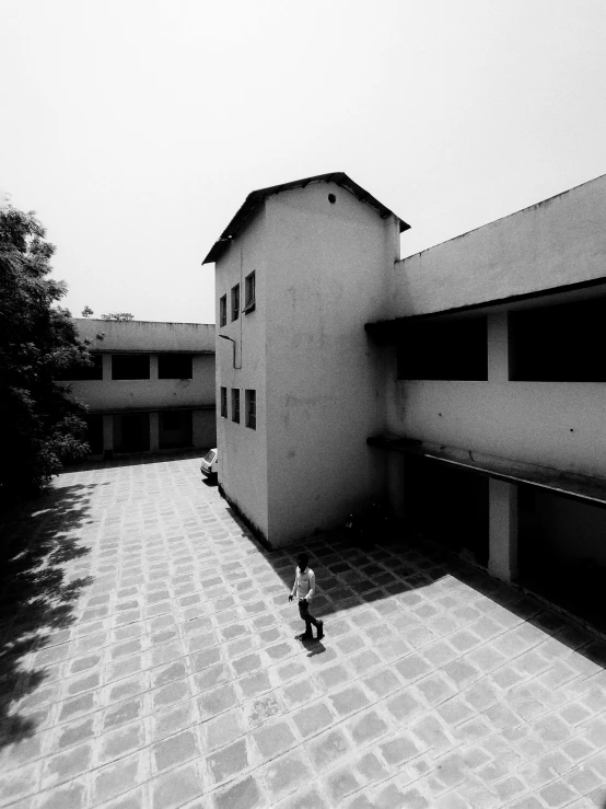 a person stands outside a building with an open courtyard