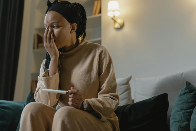 a woman is sitting on a couch holding a paper in her hand