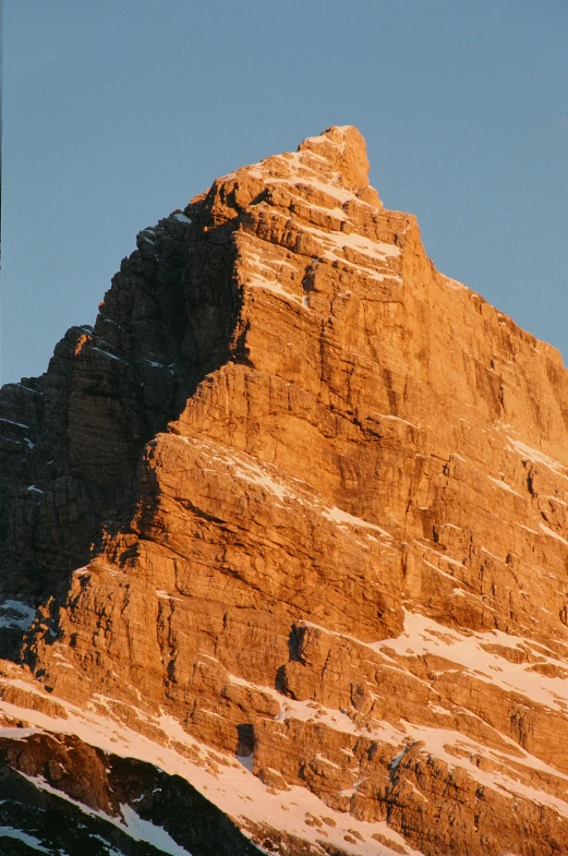 mountain peaks rise up to the sky and light brown snow