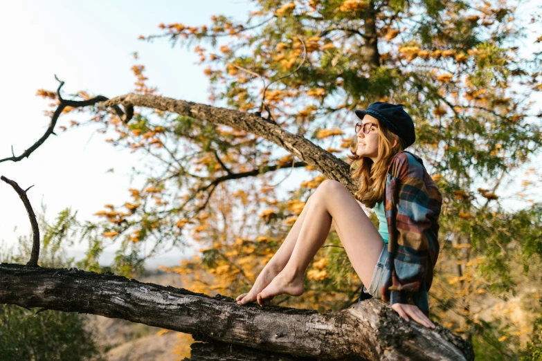 a woman sitting on a nch of a tree