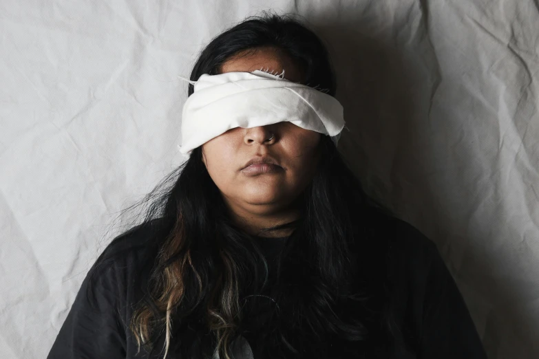 a woman laying in bed with an eye mask on her eyes