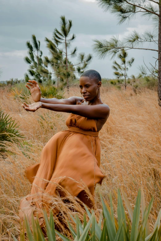 a young african woman stands in the grass