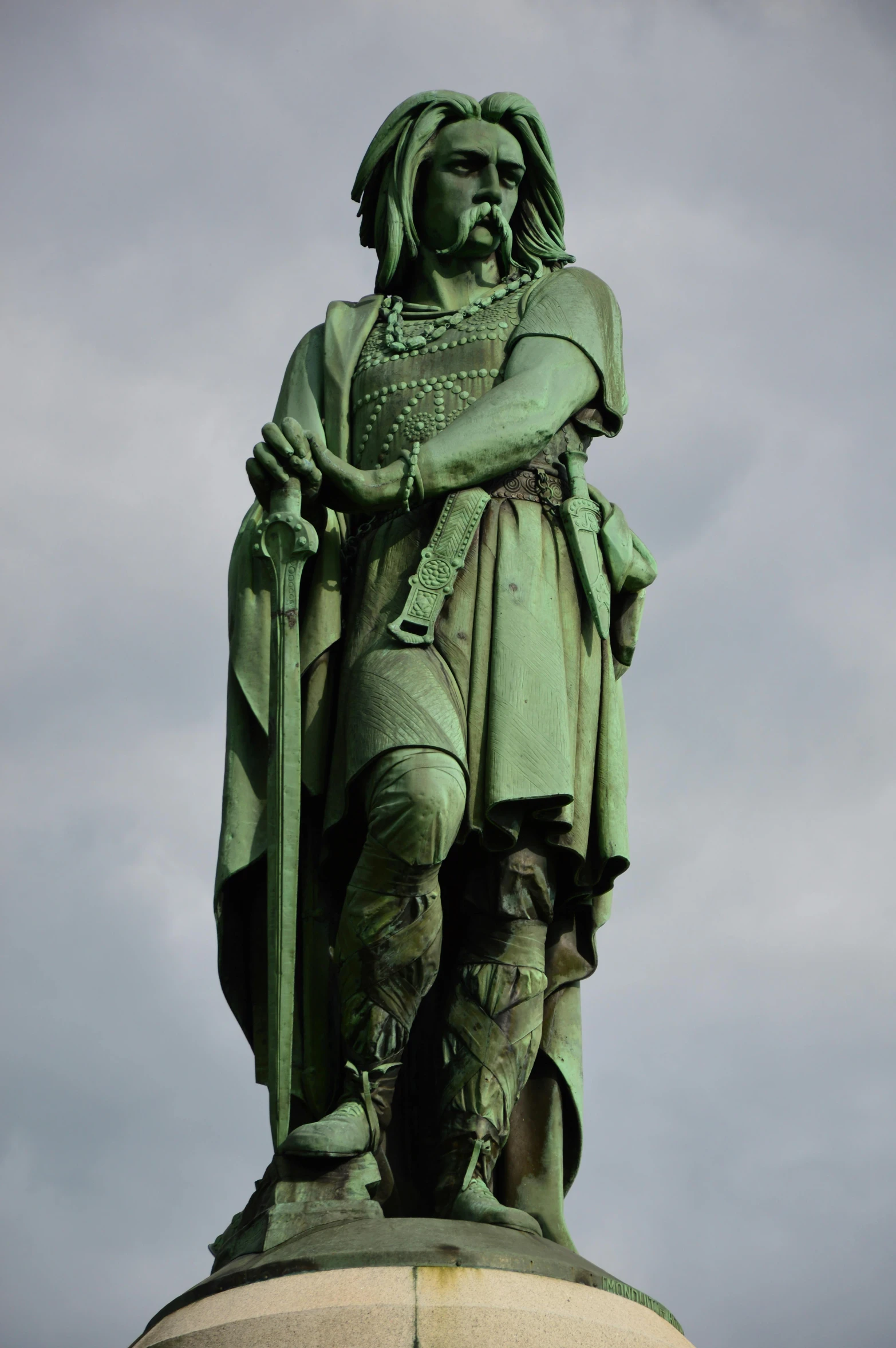 a statue on a hill surrounded by clouds