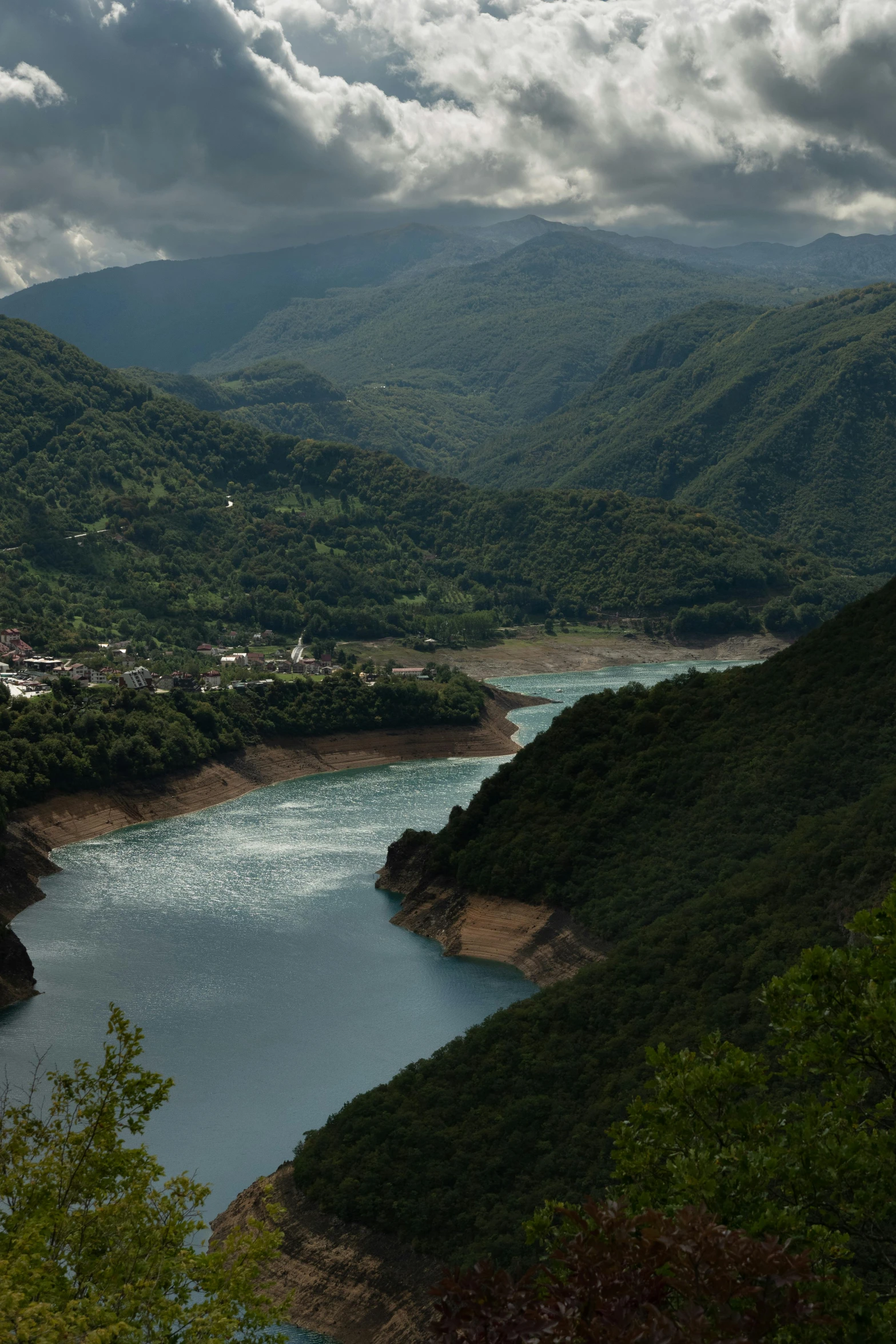 a view of mountains and a river in the foreground