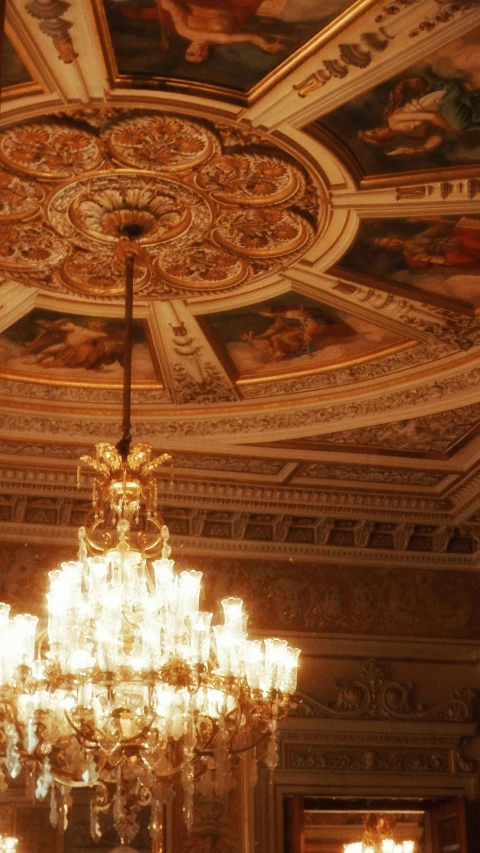 a chandelier in a fancy room with many paintings