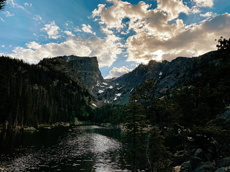 trees and rocks surround a calm river