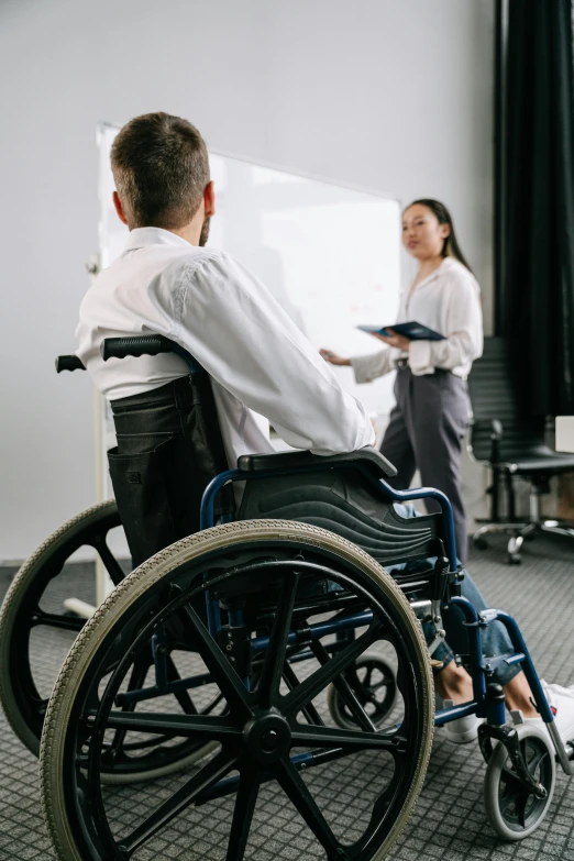 a man in a wheelchair and a woman standing behind him