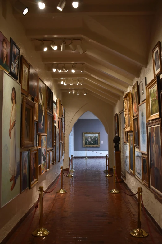 long hallway that has multiple paintings and pictures on the walls