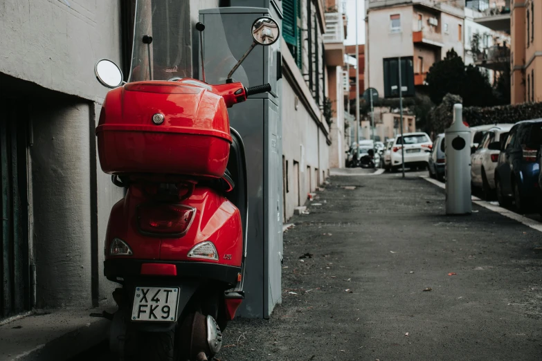 a scooter is parked on a sidewalk near an apartment building