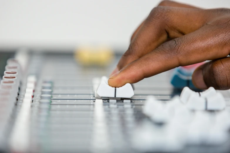 hand hing small white object on sound equipment