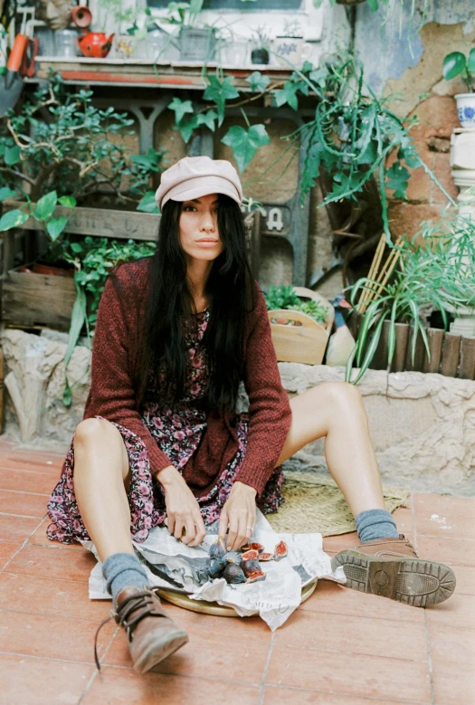 a woman sitting on a floor looking at the ground