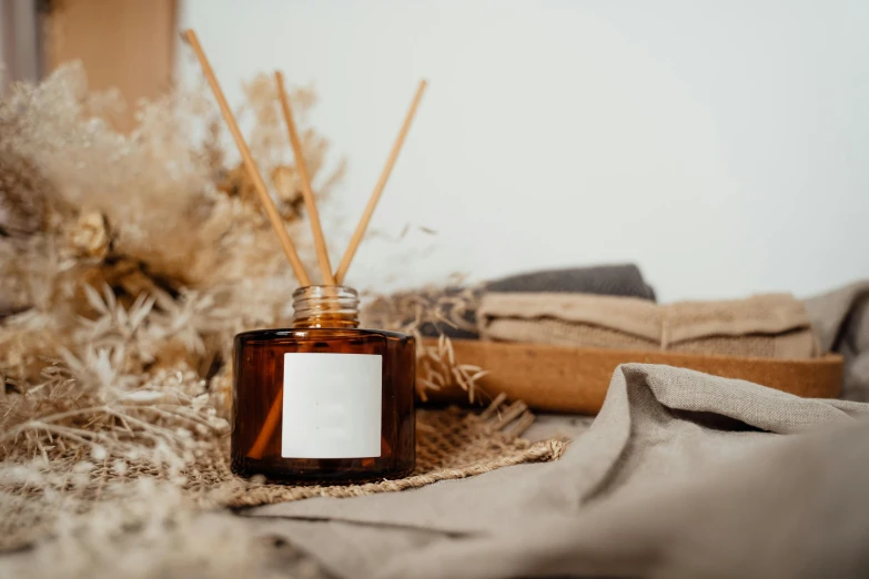 an empty jar of brown liquid sitting on top of burlap