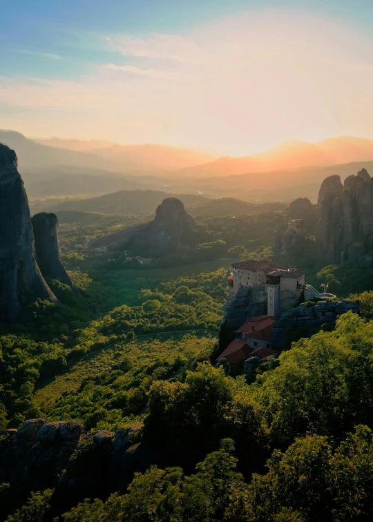 a castle in the mountains near some trees