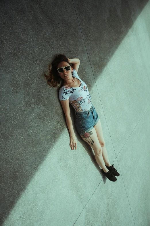 a person with a pair of sunglasses lying on the ground