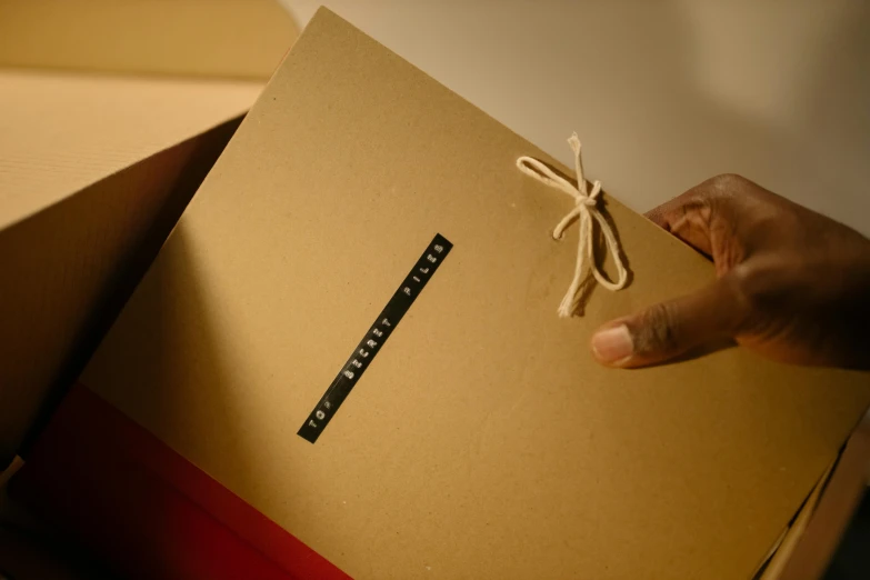 a brown box sitting on top of boxes, tied up with rope