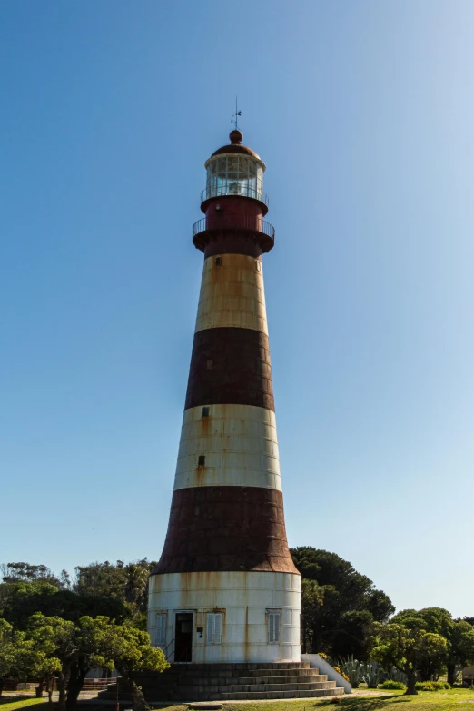 a lighthouse in a grassy area with trees